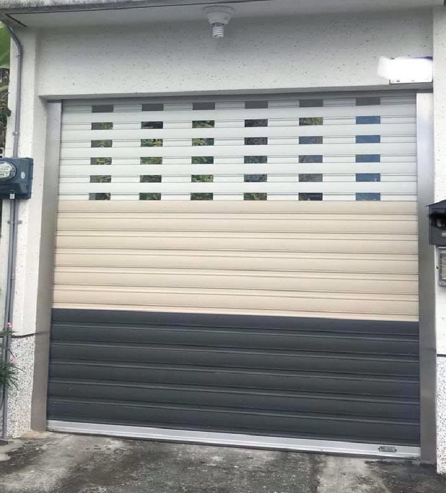 這張照片是一扇現代化的捲門,門上有一排排整齊的橫條,並帶有透明的視窗,使它既美觀又實用。