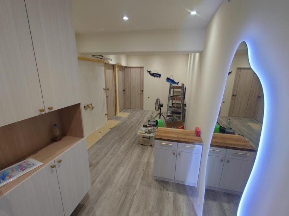 這張照片是一個現代化的浴室,最重要的是一個大大的鏡子,鏡子上有藍色的燈光,讓浴室看起來更明亮。