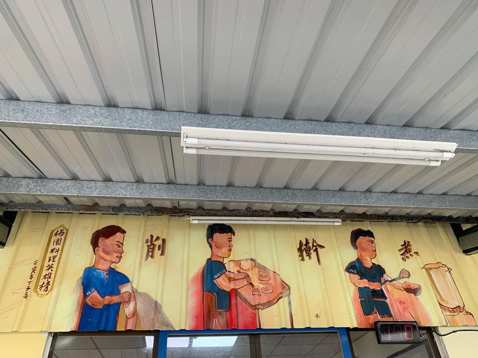 這張「牆壁上畫著三個人物」的照片是,這三個人物看起來像是餐飲業的員工,牆壁上也寫著菜單和店名。