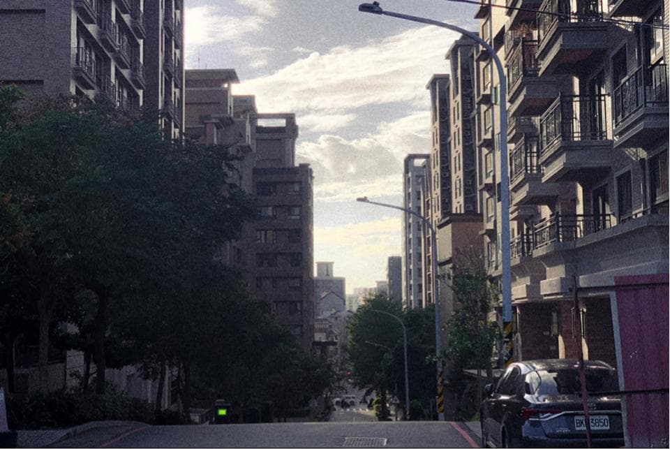 這張「建築物和街道」的照片是一個繁忙的城市街道,街道兩旁都是高樓大廈,街道上還有幾輛汽車。