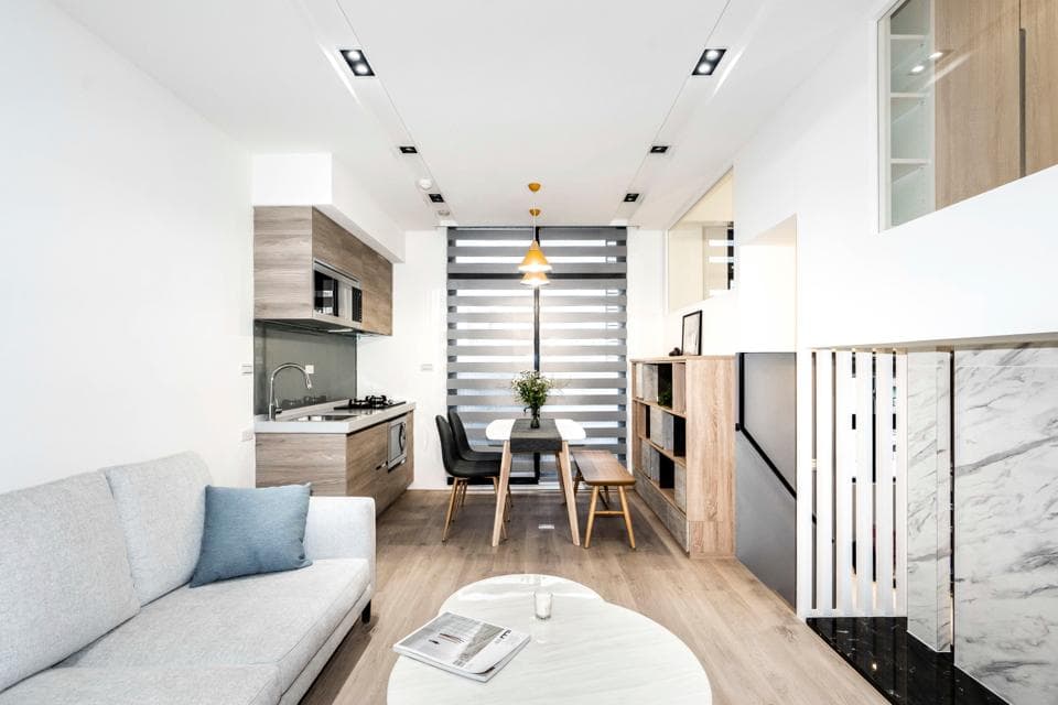 這張照片是一間現代化的公寓客廳,最顯眼的是中間的白色沙發和旁邊的咖啡桌。