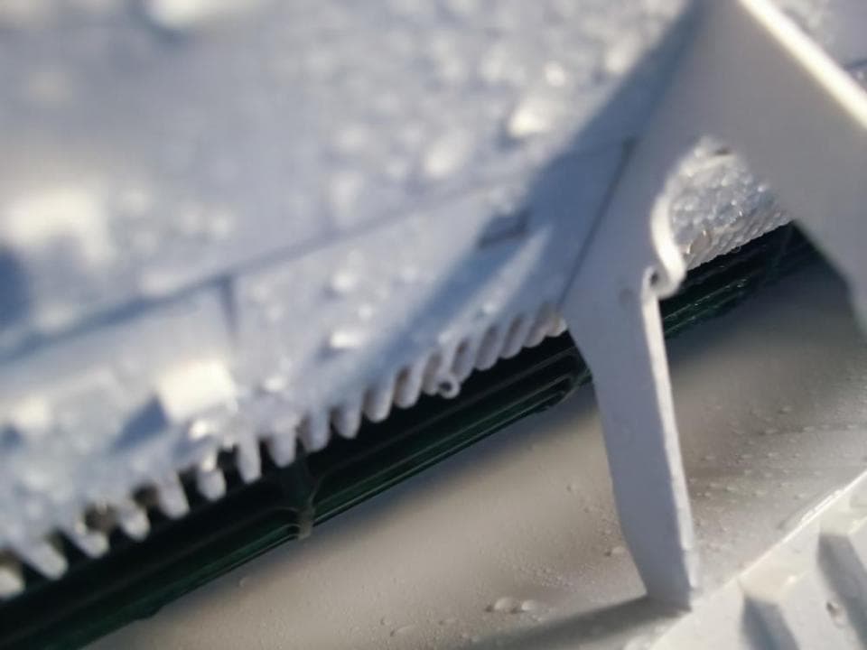 1) 照片顯示一個白色金屬結構,部分覆蓋著一個網格狀物體