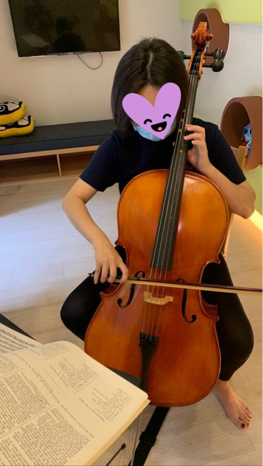 1) 照片中有一位女性,她穿著黑色衣服,正在演奏大提琴
