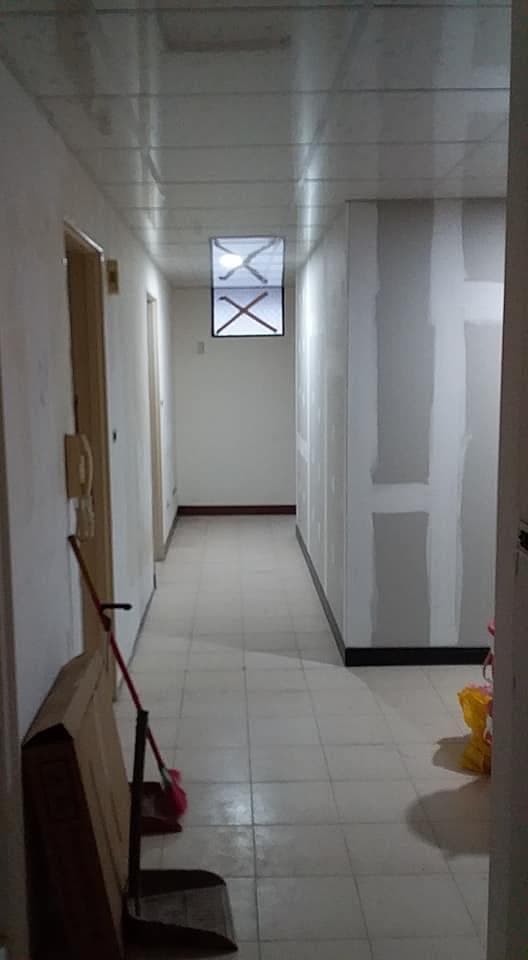 1) 照片顯示一個空蕩蕩的走廊,走廊的牆壁是白色,地板是米色的