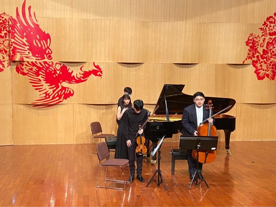 1) 這張照片顯示了四位音樂家在一個音樂廳舞台上演奏