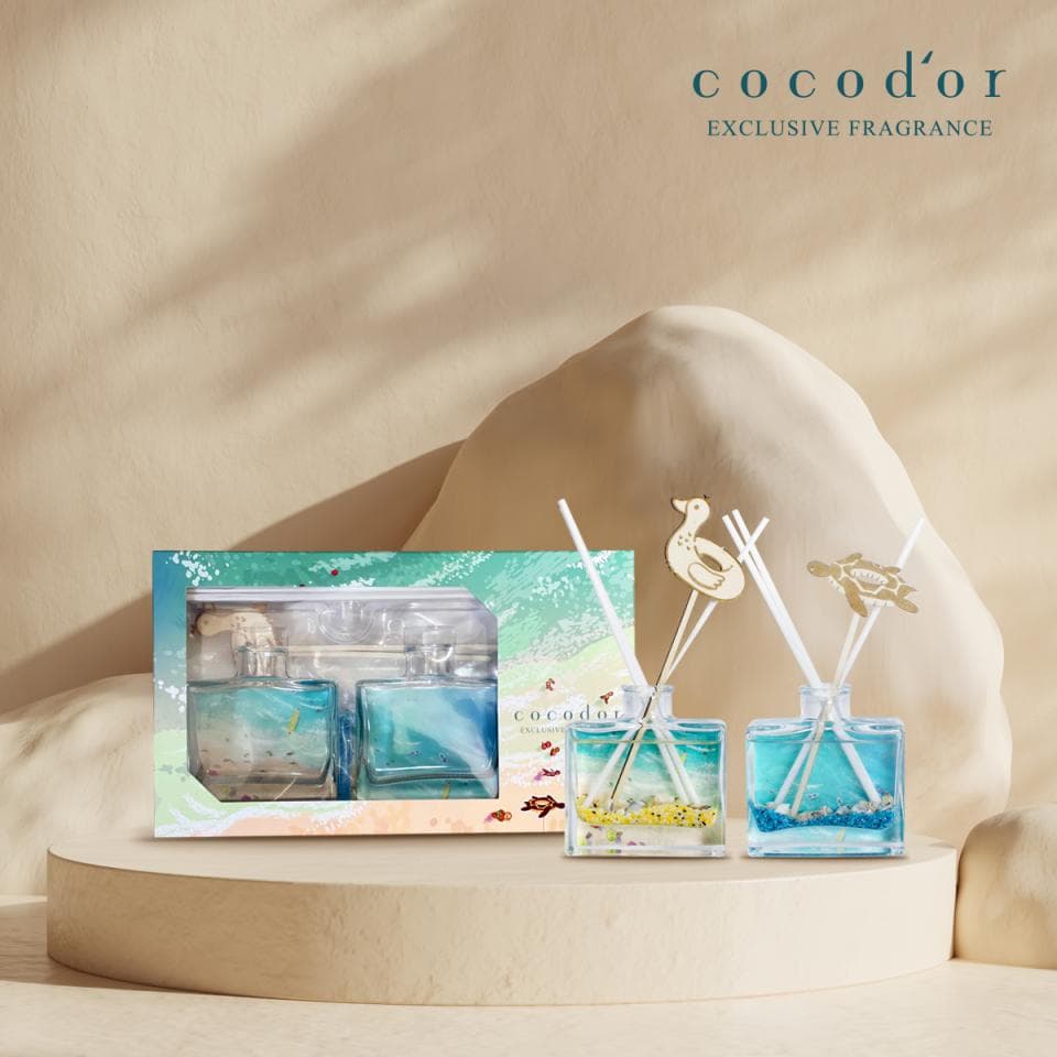 這張照片是兩個裝在玻璃瓶中的香氛瓶,瓶身裝飾著海洋主題的圖案,瓶子裡也裝有貝殼和沙子等裝飾,看起來非常漂亮。