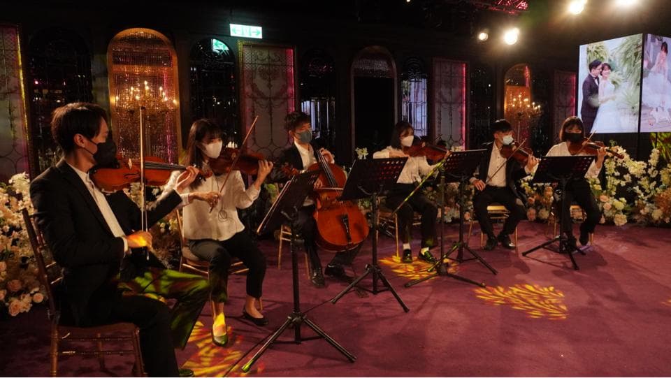 這張「弦樂四重奏」的照片是在一個華麗的場地裡,演奏者們都戴著口罩,並演奏著古典音樂。