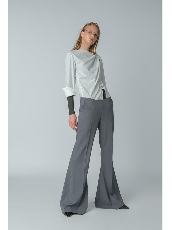 這張照片是一個穿著灰色喇叭褲的女性。褲子從膝蓋以下開始擴大,呈現喇叭形狀,十分顯眼。