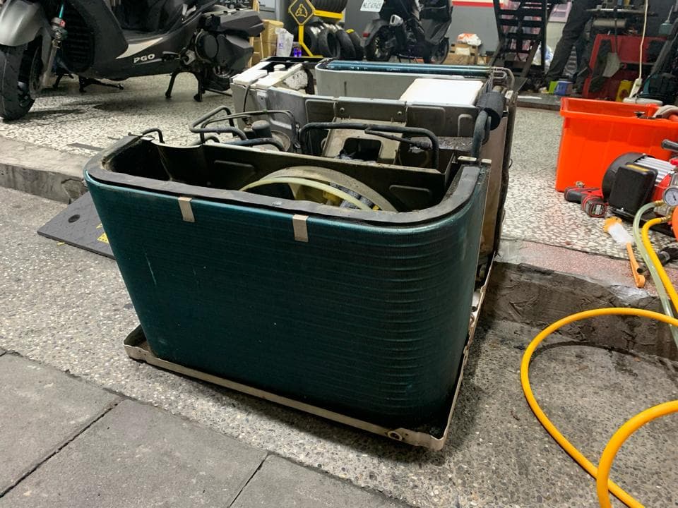 這張照片是一台拆解的冷氣機,它有一個藍色的金屬外殼,上面有許多橫條。