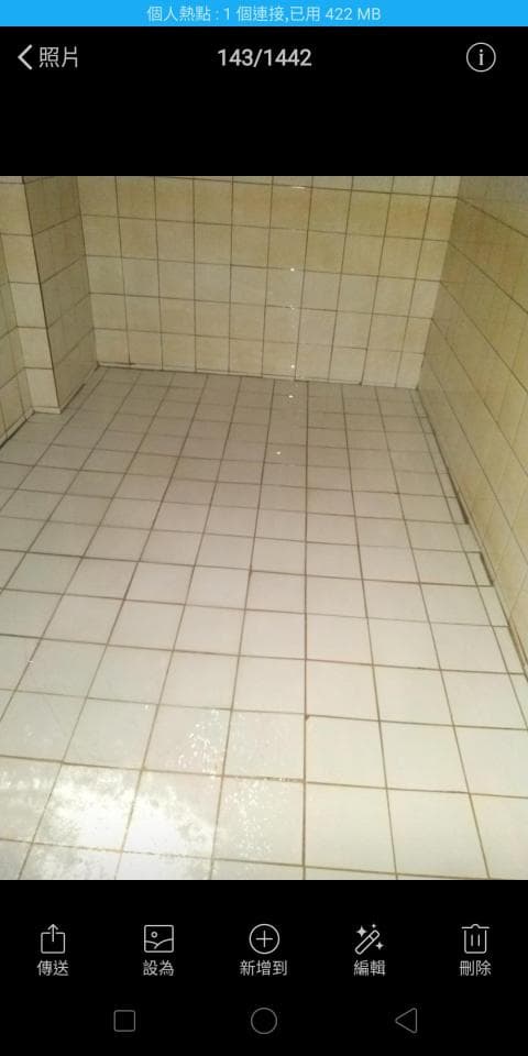 這張照片是一間浴室,最重要的是浴室的瓷磚地板,地板上有一些水漬,看起來像是剛剛清理完畢。