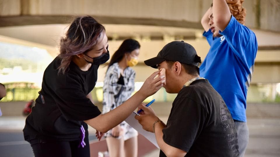 這張「四個朋友在戶外玩耍」的照片是,一個女生正在幫另一個男生擦臉,他們都笑得很開心。