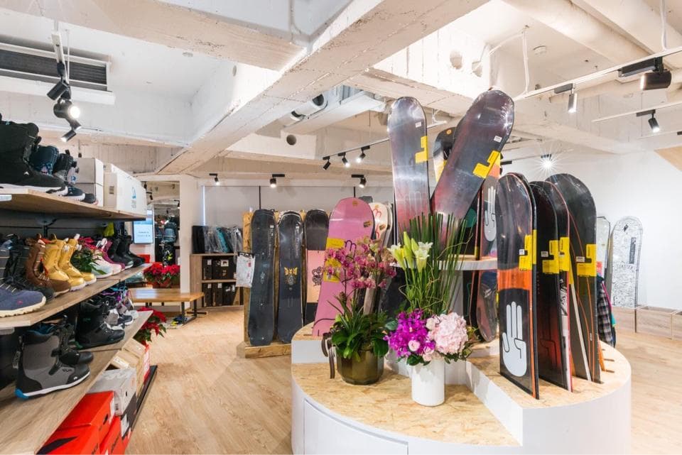這張「滑雪板店」的照片是一家裝潢現代化的商店,店內擺放著各式各樣的滑雪板,以及花卉裝飾。