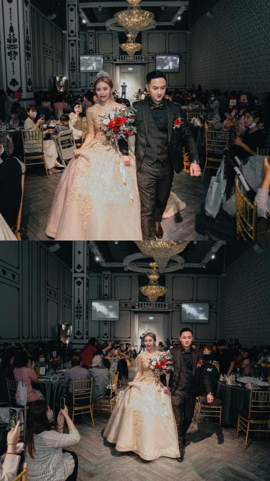 這張照片是一對新人正在婚禮現場進行婚禮進場儀式,新娘穿著白色婚紗,新郎則穿著黑色西裝,他們手牽手走向前方,露出幸福的笑容。