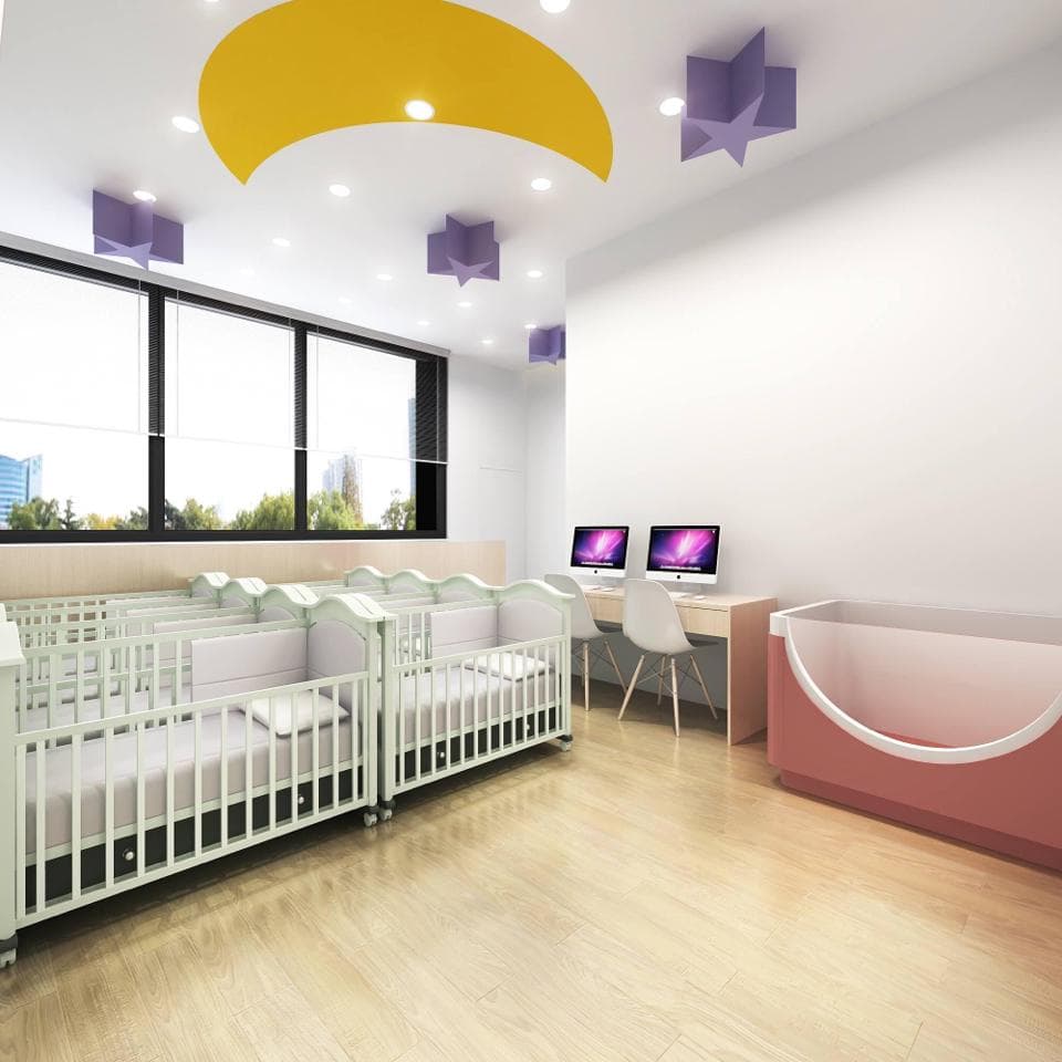 這張「幼兒園」的照片是一間有幾張嬰兒床、一個小浴缸和兩臺電腦的房間。房間的牆壁上有幾個星星和一個月亮。