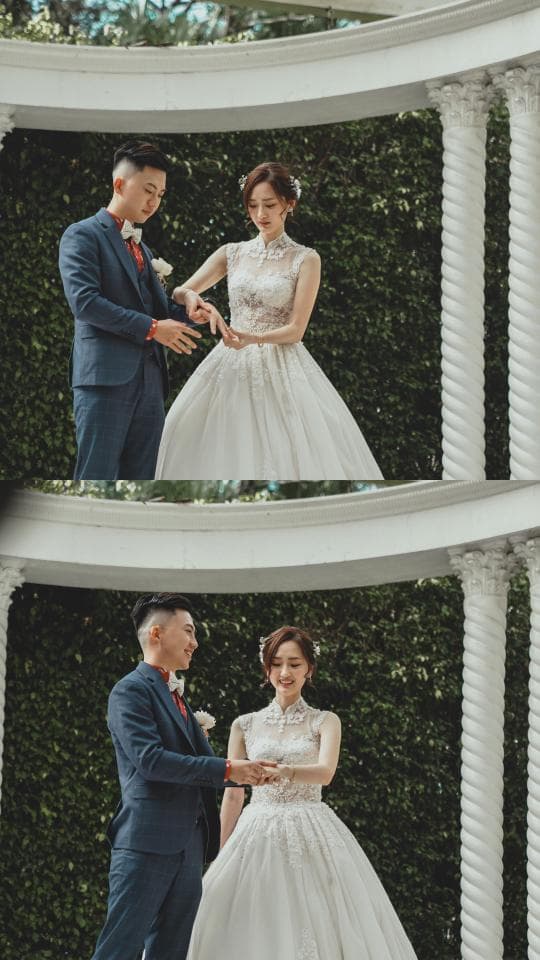 這張照片是一對新人正在交換戒指,他們身穿婚紗禮服,面帶笑容,看起來非常幸福。