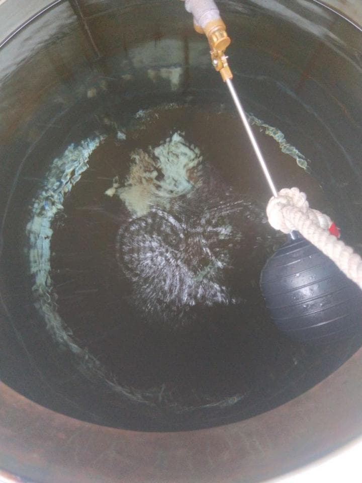 1) 照片顯示一個水箱,裡面裝滿水,水箱頂部有一個浮球閥,水從水箱底部噴出