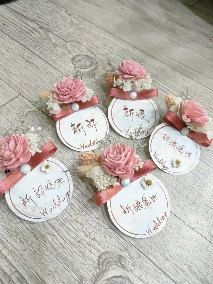 1) 照片顯示五個裝飾著乾燥花朵的圓形標籤,上面寫著“結婚快樂”
