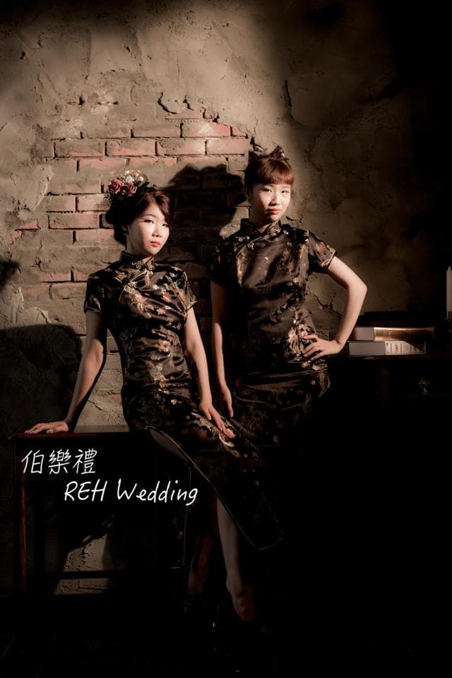 這張「婚紗照」的照片是兩個穿著傳統中式禮服的女性站在紅磚牆前,她們看起來很開心,充滿著幸福的氣息。