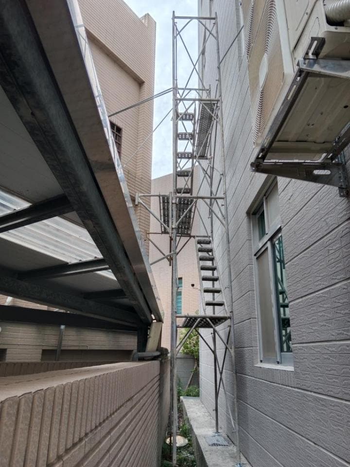 這張「鷹架」的照片是一座用來進行建築物外牆維修的鷹架,它位於兩棟建築物之間狹窄的空間裡。