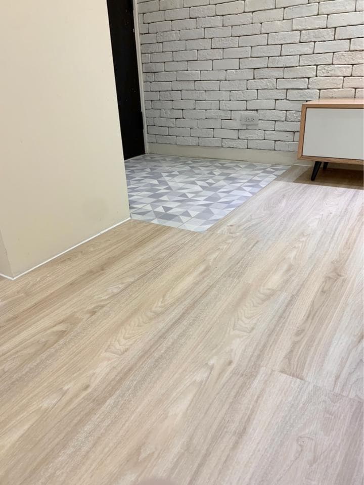 1) 照片顯示一個有著白色磚牆和淺色木地板的房間