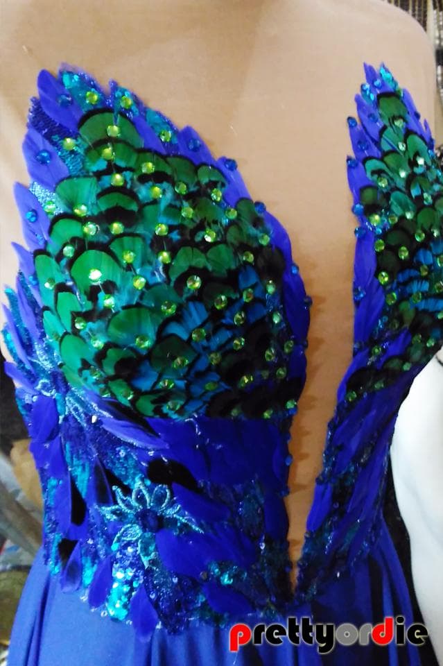 這張「孔雀羽毛」的照片是藍色的禮服,上面裝飾著綠色的孔雀羽毛和亮片,看起來很華麗。