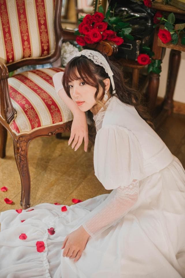 這張照片是一個穿著金色內衣的女性,她背後有一雙巨大的金色羽毛翅膀。