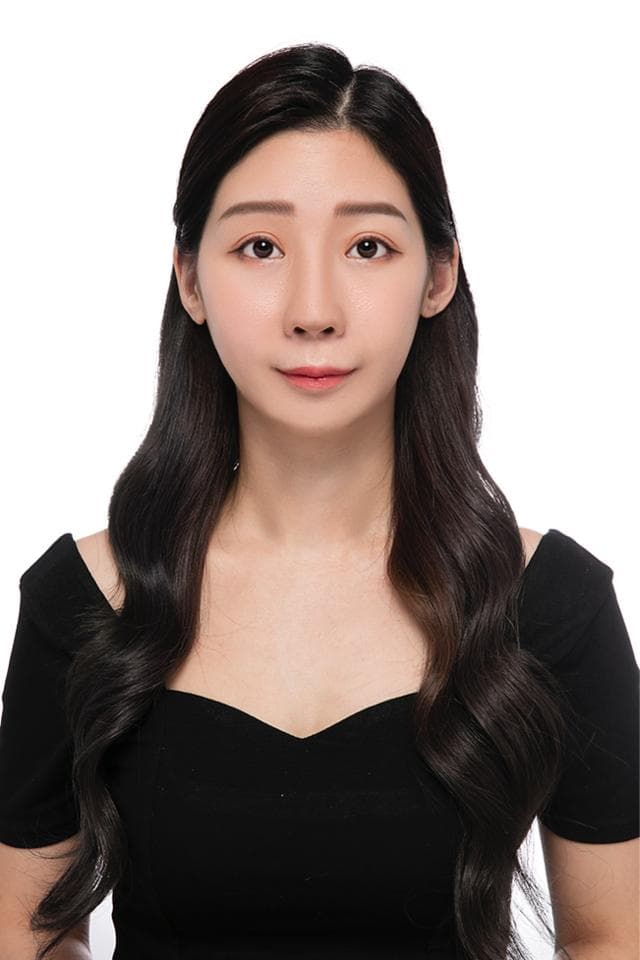 這張照片是一個年輕女性的肖像照,她留著烏黑亮麗的長髮,穿著黑色低胸上衣,看起來端莊優雅。