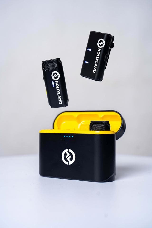 這張「無線麥克風」的照片是兩個黑色麥克風和一個充電盒,麥克風上都有 Hollyland 的標誌。