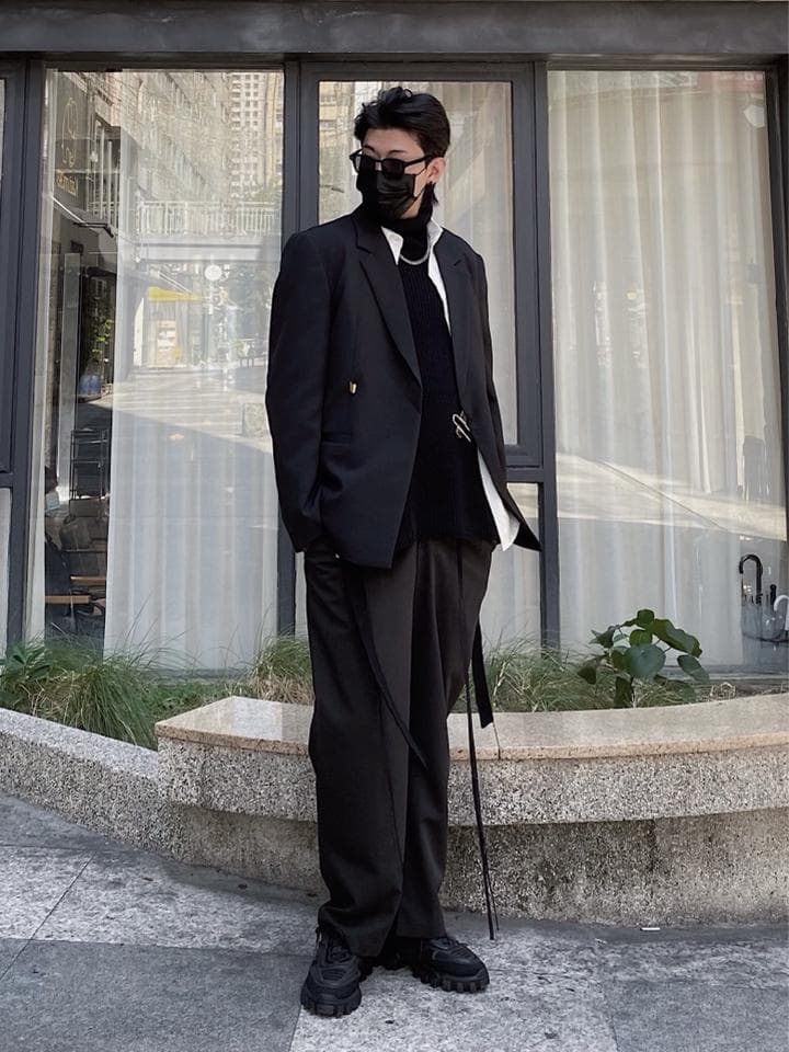 這張照片是一個穿著黑色西裝外套的男子。