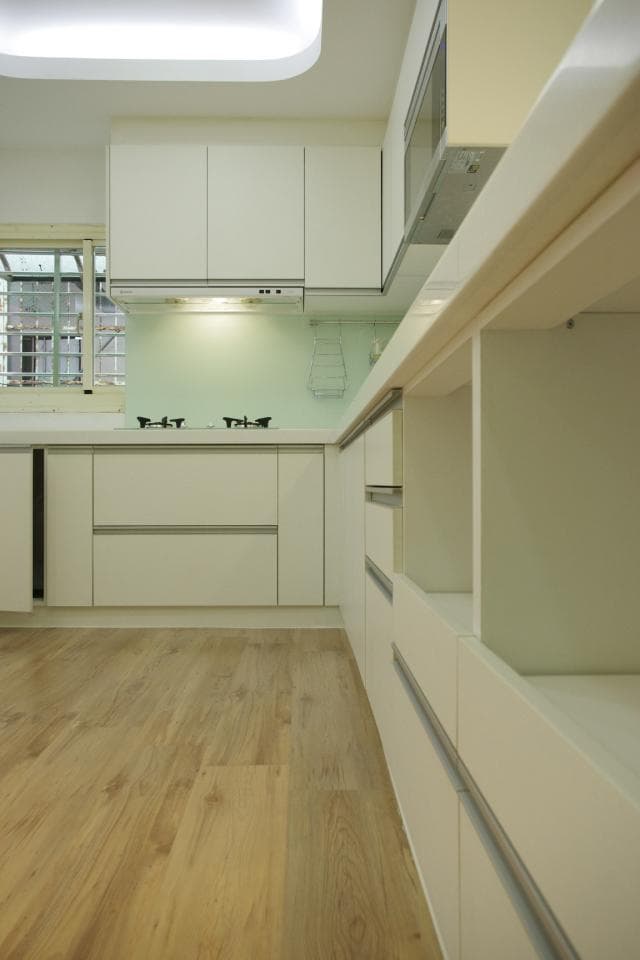 這張照片是一個現代化的廚房,最重要的是木質地板,它看起來很乾淨,而且顏色很溫暖。