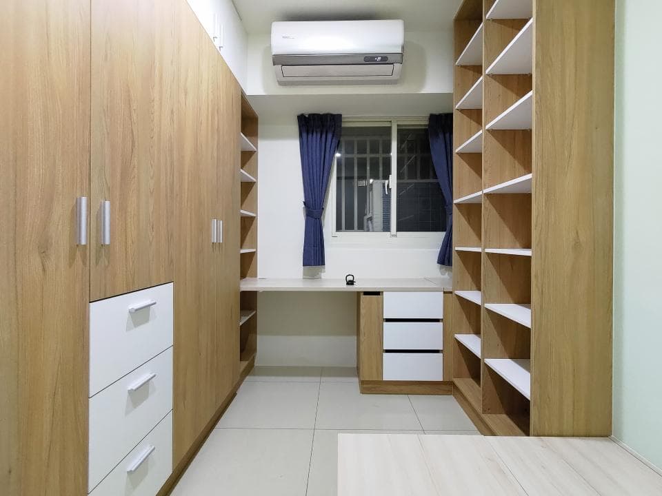 這張照片是一間帶有白色木門的臥室,房間裡有兩個大型衣櫃和一個書架,房間地板鋪著白色地磚。