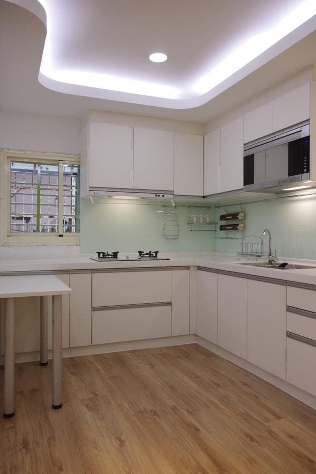 這張照片是一個現代化的廚房,地板是木紋的,非常溫馨。