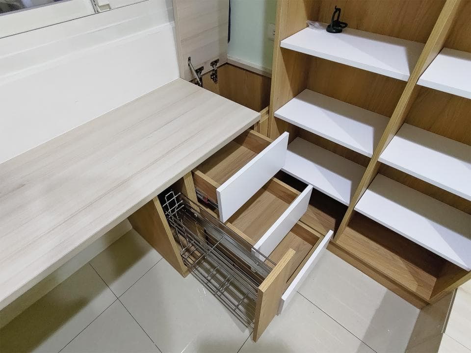 這張照片是一張木質書桌,書桌上有一個抽屜,抽屜內有金屬製的抽拉式收納架。