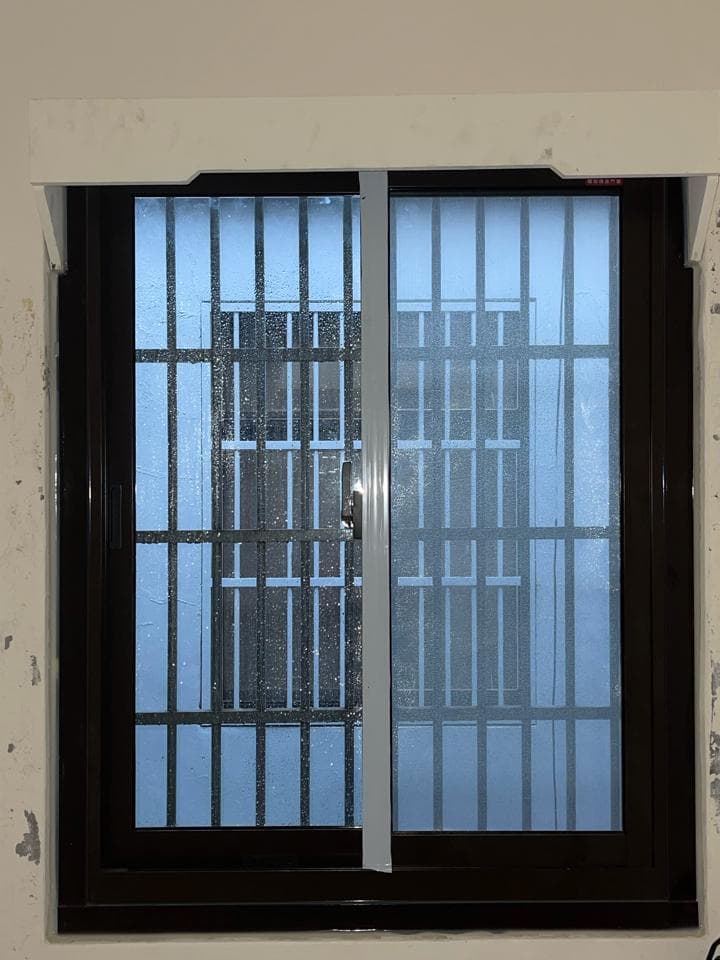 1) 照片顯示一個帶有鐵欄杆的雙層玻璃窗戶