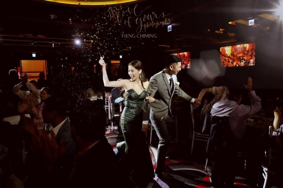 這張照片是一對新人正在跳舞,他們被拋灑著彩帶,周圍的賓客歡呼鼓掌,洋溢著幸福的氣氛。