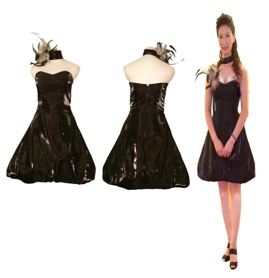 這張照片是三個穿著相同黑色禮服的女人,其中一個女人站在中間,另外兩個女人的禮服是平放的。她們的禮服設計是蓬蓬裙風格,領口處有羽毛裝飾。