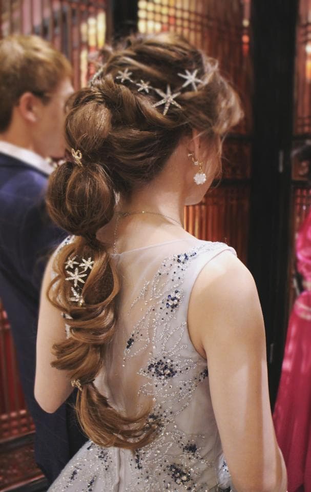 這張「新娘」的照片是,她穿著一件銀色禮服,頭髮編了一個精緻的髮型,並戴著星星形狀的髮飾,看起來非常優雅。