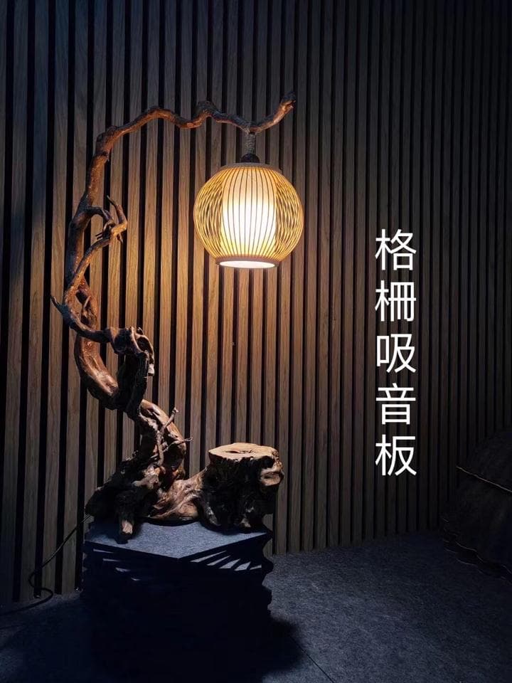 1) 照片顯示一個木頭雕刻的樹枝形狀的檯燈,上面裝有一個竹編燈罩,燈光溫暖柔和,照亮了周圍的環境
