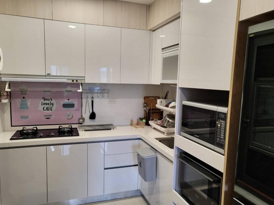 這張照片是一間廚房,照片裡最重要的是嵌入式烤箱和微波爐,它們都鑲嵌在白色櫃子裡,看起來很現代化。