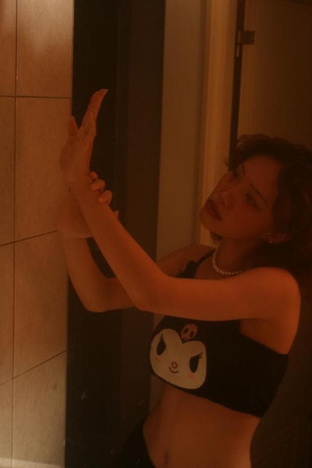 這張「女生站在浴室裡,伸手觸摸牆壁」的照片是。