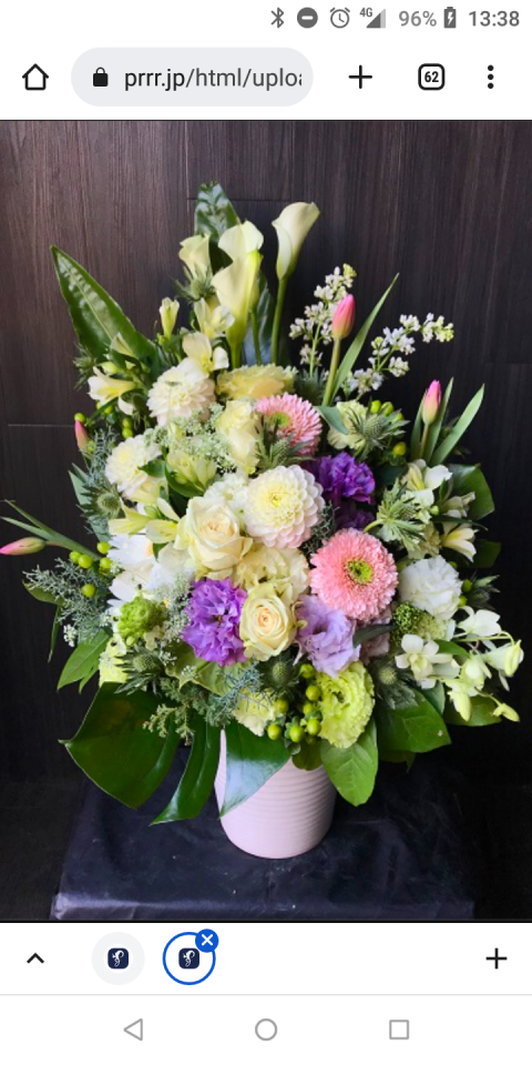 這張「花束」的照片是許多白色、粉色和紫色的花朵,放在一個白色花瓶裡。