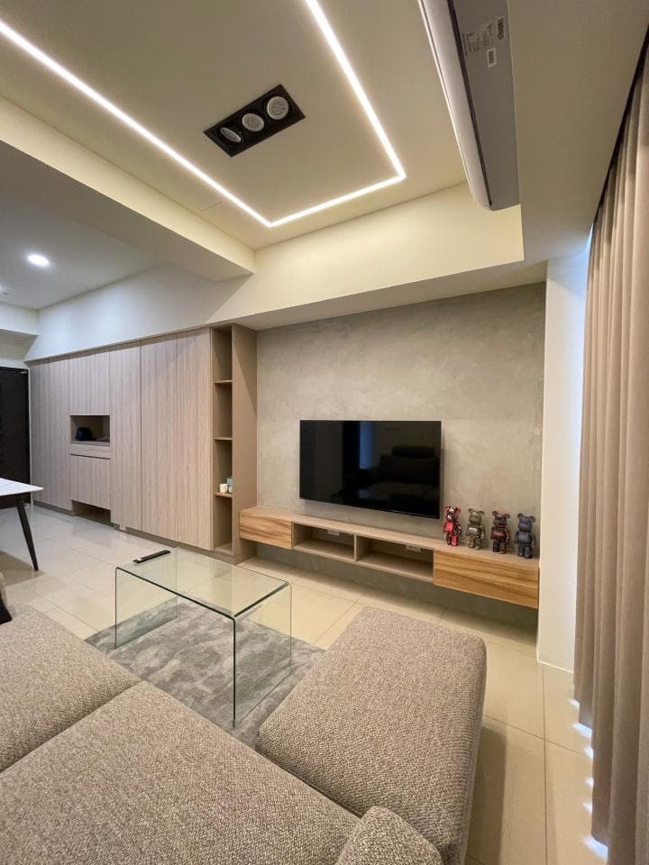 1) 照片顯示一個現代化的客廳,佈置簡潔時尚,牆壁是淺灰色,地板是米白色,客廳內有沙發、茶几、電視櫃、電視,以及一個木製書櫃