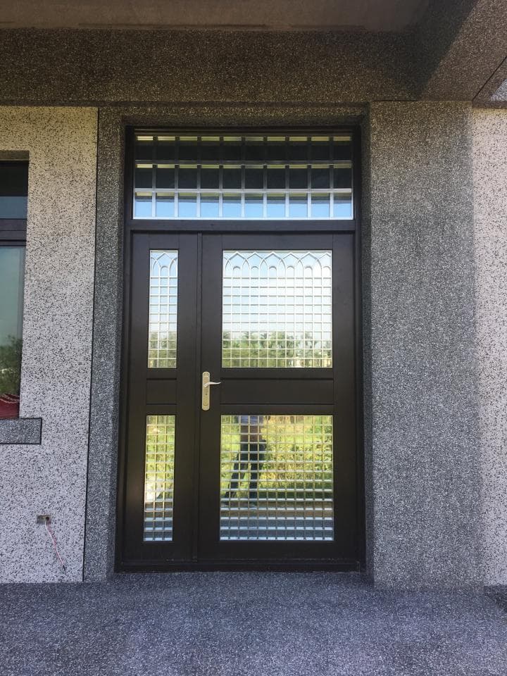 1) 照片顯示一扇有玻璃窗的雙門,門是黑色的,玻璃是透明的,玻璃窗有格子