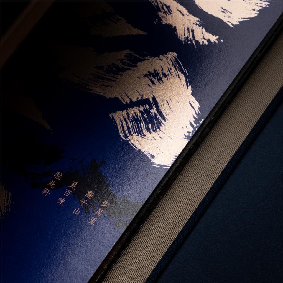 這張照片是一本深藍色封面、玫瑰金色書名的書,書名用毛筆字寫成。