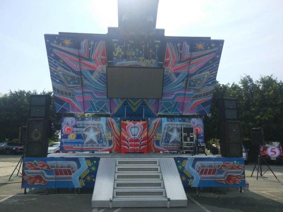 1) 照片顯示了一個舞台,舞台上裝飾著鮮豔的彩色燈光,並掛著大型的顯示螢幕