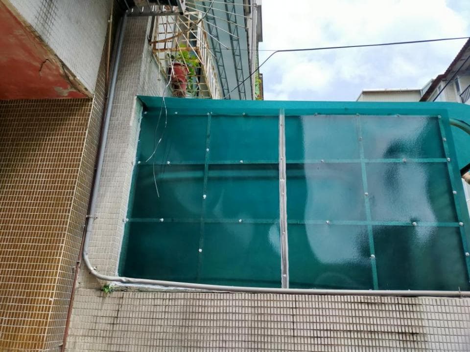 這張「建築物外牆」的照片是一個綠色玻璃窗戶,它裝在牆壁上,並有白色瓷磚地板。