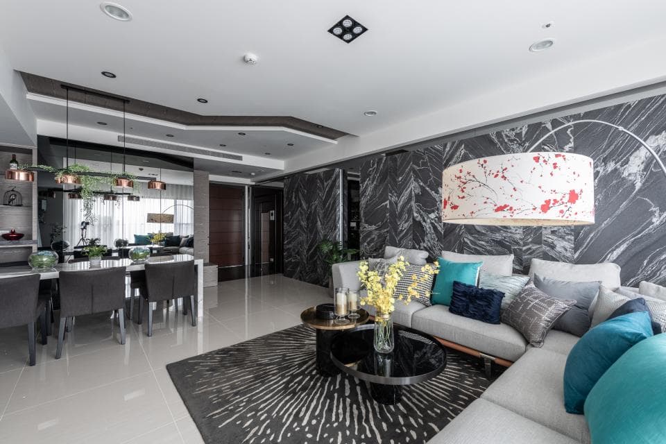 這張「現代化客廳」的照片是展示了灰黑色調的牆壁、大理石紋路的沙發、以及一個帶有花朵圖案的圓形吊燈。