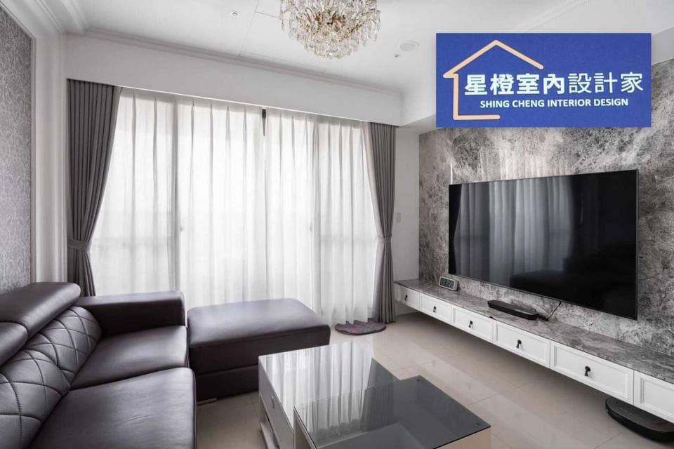 這張客廳的照片是一個現代化的客廳,有灰色沙發、茶几,以及電視牆和電視。