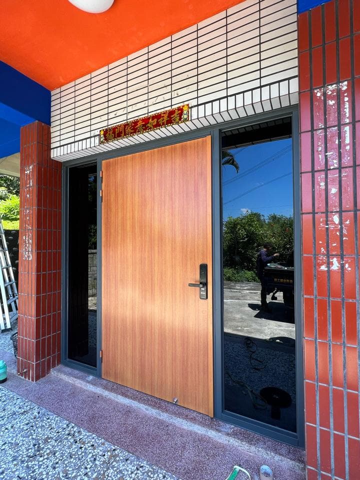 1) 照片顯示一棟建築物的外觀,有一個木製門,配有黑色金屬門把和玻璃窗