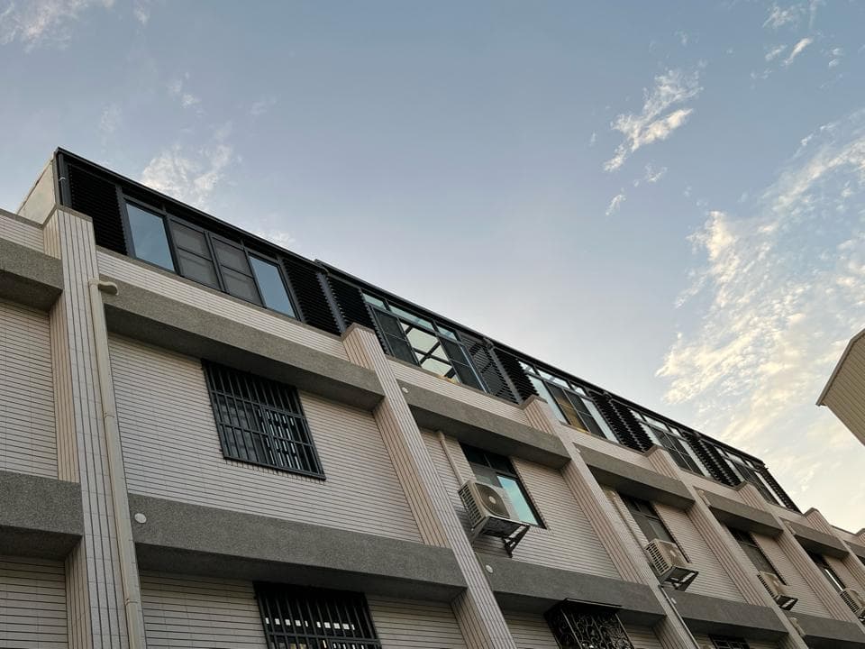 1) 這張照片顯示了一棟具有現代風格的建築物,外牆以白色為主,並帶有黑色的窗框